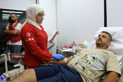 A man donates blood in the southern Lebanese city of Saida on September 17, 2024, after explosions hit locations in several Hezbollah strongholds around Lebanon amid ongoing cross-border tensions between Israel and Hezbollah fighters. Hundreds of pagers used by Hezbollah members exploded across Lebanon Tuesday, killing at least eight people and wounding Tehran's ambassador in Beirut in blasts the Iran-backed militant group blamed on Israel. (Photo by Mahmoud AL-ZAYYAT / AFP)