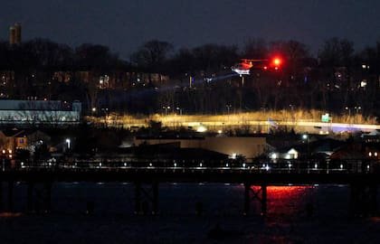 ARLINGTON, VIRGINIA - 30 DE ENERO: Un helicóptero ayuda con las operaciones de búsqueda y rescate sobre el río Potomac cerca del aeropuerto Ronald Reagan de Washington el 30 de enero de 2025
