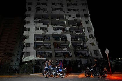 Varias personas se congregan frente a un edificio dañado tras un terremoto en Catia La Mar