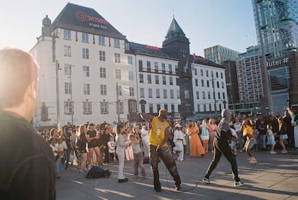 Un DJ actúa ante una multitud reunida en una plaza junto a la estación central de trenes de Oslo, Noruega, el 20 de junio de 2026
