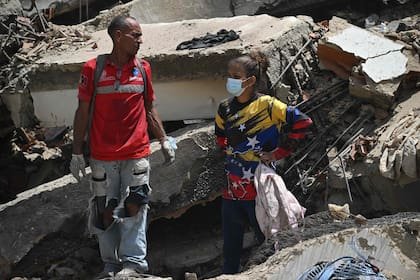 Voluntarios locales se toman un respiro en medio de los trabajos de rescate en La Guaira