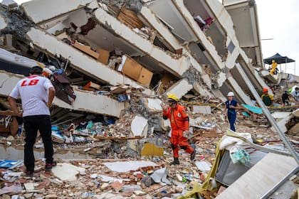 Voluntarios y un rescatista mexicano ayudan a encontrar sobrevivientes en un edificio derrumbado en Caraballeda, estado de La Guaira, Venezuela, el 30 de junio de 2026, tras los dos terremotos del 24 de junio.
