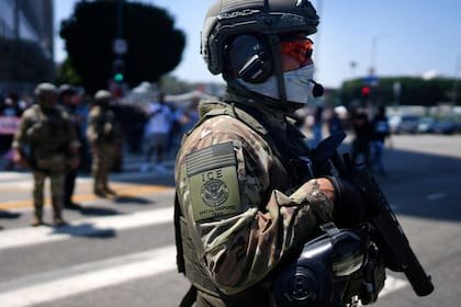 Un agente del ICE observa una manifestación contra las redadas migratorias frente al Centro de Detención Metropolitano en Los Ángeles.