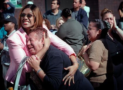 Dos mujeres se abrazan mientras ven arder el World Trade Center en Nueva York