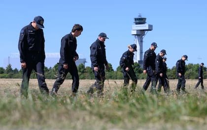 Agentes de policía registran un campo en el aeropuerto de Leipzig/Halle tras un incidente con un dron