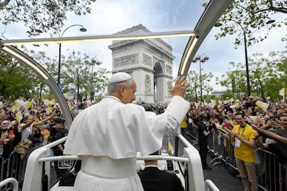 El papa León XIV saludando a la multitud desde el papamóvil frente al Arco de Triunfo, de camino a la plaza de la Concordia, en el centro de París