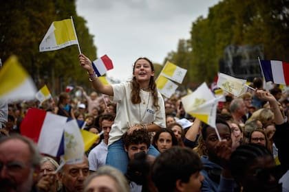 Fieles reunidos en la avenida de los Campos Elíseos asisten a una misa solemne al aire libre celebrada por el papa León XIV en la plaza de la Concordia, en el centro de París