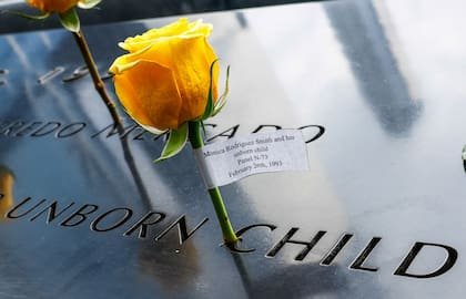 Flores son depositadas junto al Estanque Reflectante del Memorial del 11-S, donde visitantes de distintos lugares se reúnen para recordar a las víctimas