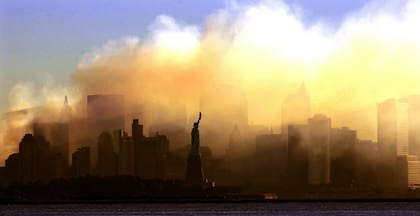 La Estatua de la Libertad se puede ver con las primeras luces desde Jersey City, Nueva Jersey, mientras el horizonte del bajo Manhattan está oscurecido por un denso humo la madrugada del sábado 15 de septiembre de 2001