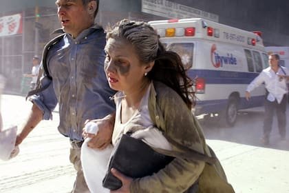 La gente huye de la escena cerca del World Trade Center de Nueva York después de que terroristas estrellaran dos aviones contra las torres el martes 11 de septiembre de 2001