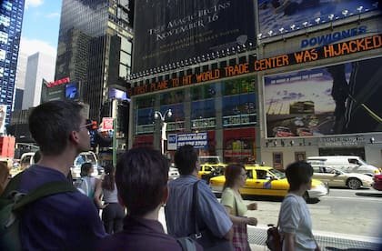 La gente ve pasar las noticias en Times Square sobre los ataques terroristas al World Trade Center en Nueva York, el martes 11 de septiembre de 2001