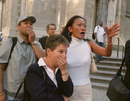 Las personas frente a la Catedral de San Patricio de Nueva York reaccionan con horror mientras miran por la Quinta Avenida hacia las torres del World Trade Center después de que los aviones se estrellaran contra sus pisos superiores