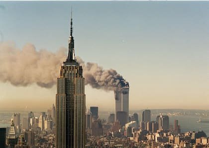 Las torres gemelas del World Trade Center arden detrás del Empire State Building en Nueva York
