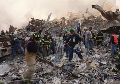 Los bomberos y el personal de emergencia retiran los escombros del lugar del colapso de las torres del World Trade Center en Nueva York, el jueves 13 de septiembre de 2001