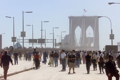 Personas abandonan Manhattan a pie rumbo a Brooklyn después de que los puentes fueran cerrados tras el derrumbe del World Trade Center