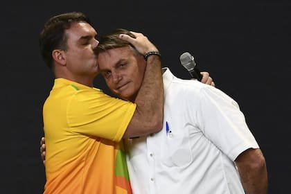 Flavio Bolsonaro besa a su padre, el entonces presidente, durante un acto del Partido Liberal (PL), en un centro de convenciones de Brasilia