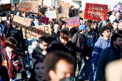 Manifestantes sostienen pancartas durante una protesta a lo largo de la circunvalación de La Rochelle, en el oeste de Francia, el 17 de octubre de 2026. La acción forma parte de una convocatoria de movilización a escala nacional que reúne a diversos colectivos —desde antiguos «chalecos amarillos», estudiantes de secundaria y universitarios, hasta activistas climáticos e incluso agricultores— para protestar contra el «alto costo de la vida»