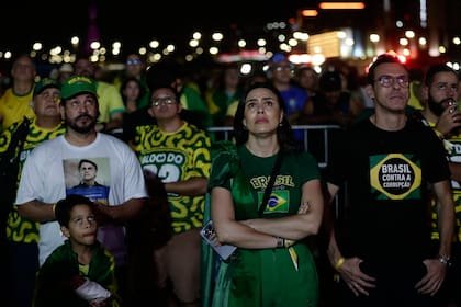 Simpatizantes del candidato opositor a la presidencia, el senador Flavio Bolsonaro, reaccionan a los resultados del balotaje presidencial en Brasilia