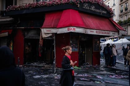 Una mujer pasa frente al bar "La Barrique", quemado durante una jornada de movilización en París, el 17 de octubre 