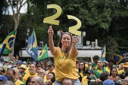 Una simpatizante de Flavio Bolsonaro sostiene figuras recortadas con la forma del número 22 durante un acto de campaña en la avenida Paulista, en San Pablo, Brasil